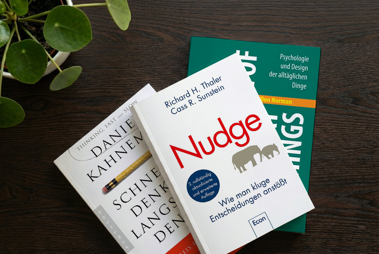 drei Bücher und eine Topfpflanze auf einem Hochschreibtisch