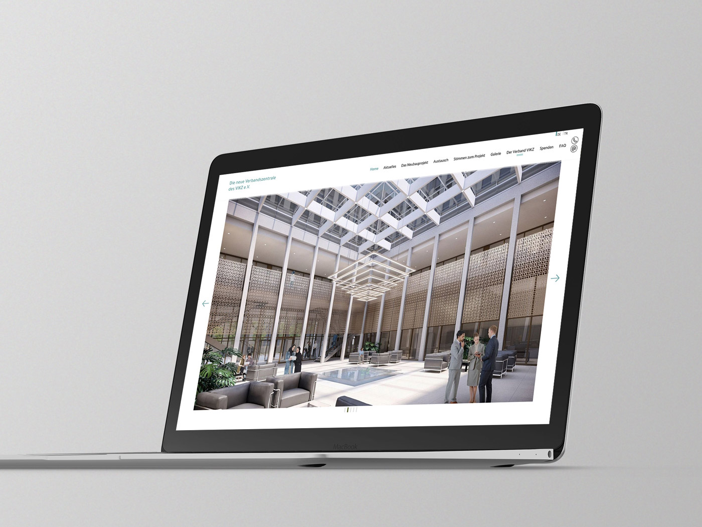 Home-Seite der neuen Website zum Bau der VIKZ-Verbandszentrale auf einem Laptop vor grauem Hintergrund